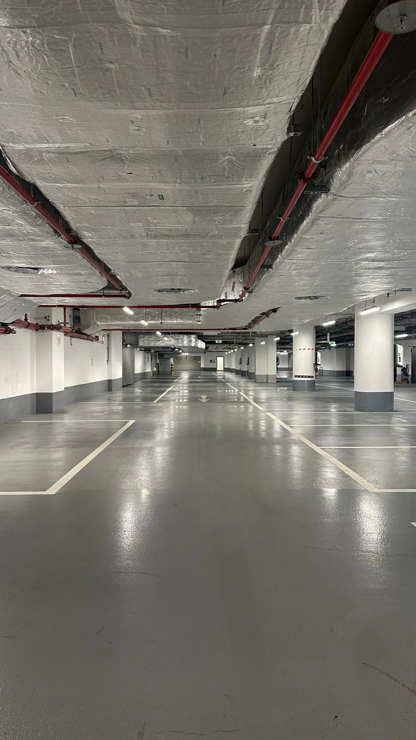 Freie Stellplätze und eine durchgehende Fahrspur zwischen den Säulen einer Tiefgarage.